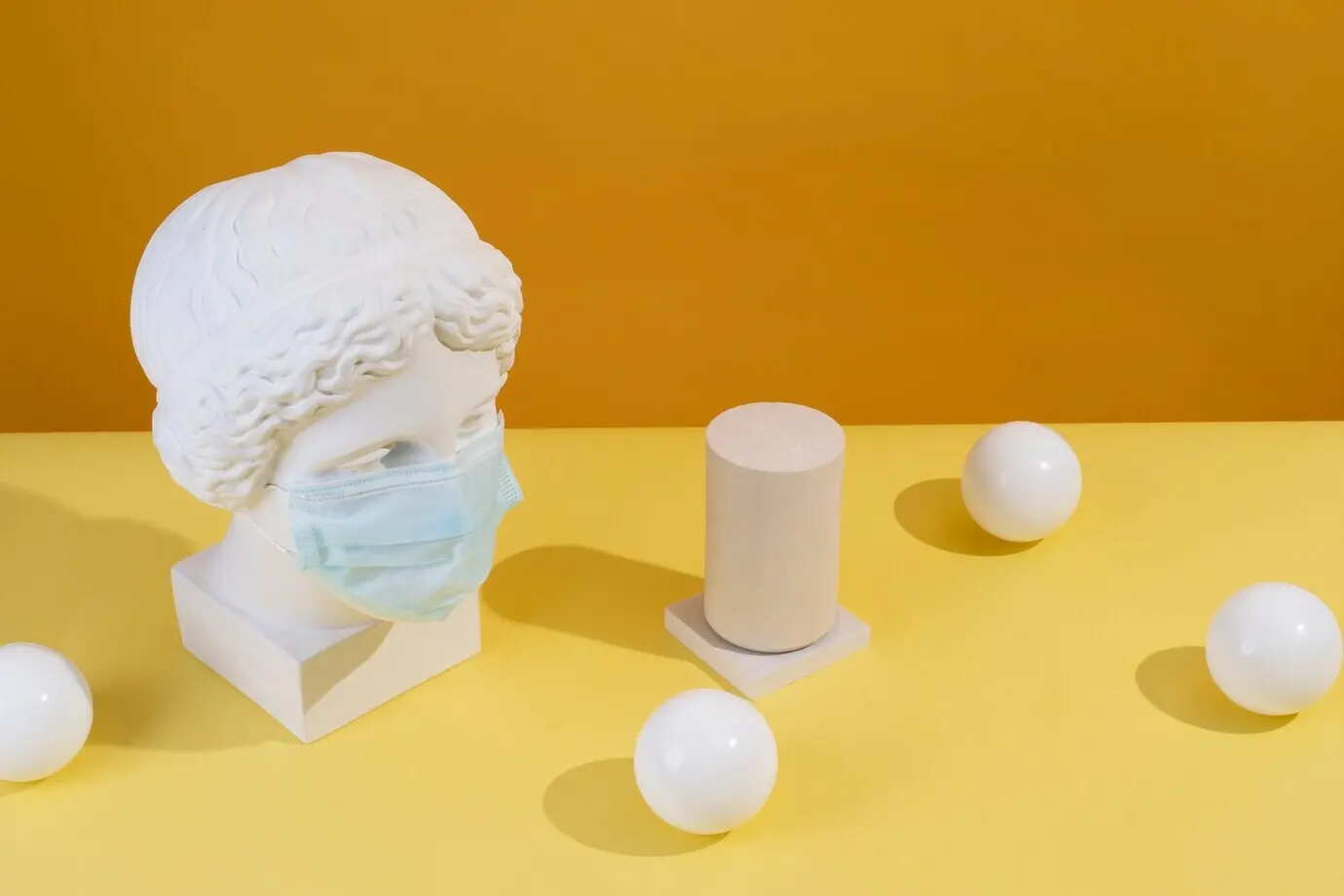 Marmorskulptur einer historischen Persönlichkeit mit medizinischer Maske und Kugeln.